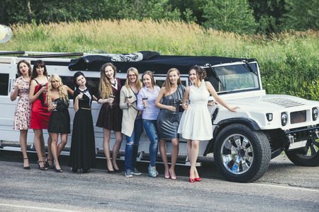 Young beautiful happy women celebrate bachelorette party in a convertible limousineの写真素材