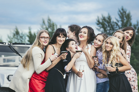 Young beautiful happy women celebrate bachelorette party in a convertible limousineの写真素材
