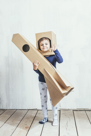 Child little girls playing spaceman with a cardboard rocket and a cardboard helmetの写真素材