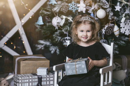 Beautiful little girl child in a happy Christmas at home with giftsの写真素材