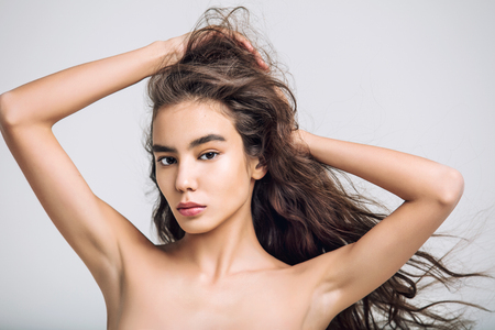 Young beautiful girl model Asian brunette with long hair posing in Studio on isolated backgroundの写真素材