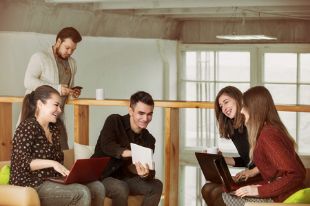 Young people do business or organize a startup together communicating in a loft-style roomの写真素材