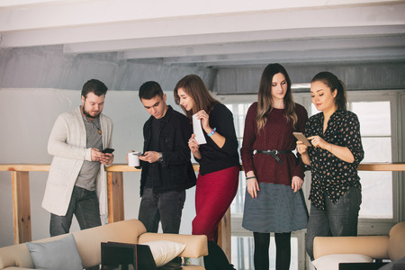 Young people do business or organize a startup together communicating in a loft-style room