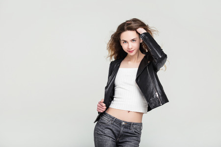 Model beautiful young girl with blond hair and blue eyes in a black jacket fashionable in the Studioの写真素材