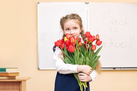 Beautiful girl baby the girl happy with a smile in the classroom with the flowersの写真素材