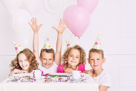 Happy beautiful cute kids smile at the holiday party with balloons and confetti together at the...
