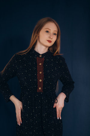 Young girl in studio in dress on blue background