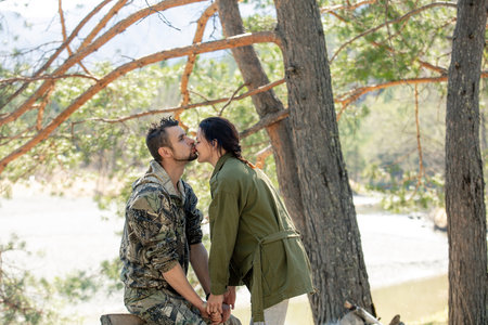 A man and a woman couple, tourists relax in the forest at a campsite togetherの写真素材