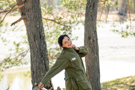 A female tourist in nature in the forest is relaxing at a campsite, happyの写真素材