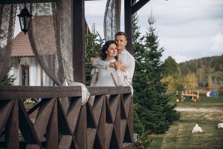 Beautiful happy couple in love man and woman, portrait on the terrace of the houseの写真素材