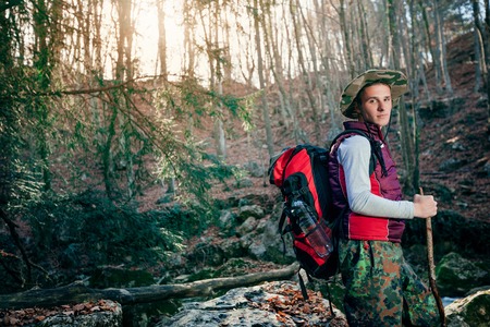 Adventure man hiking in woods with backpack, outdoor lifestyleの写真素材