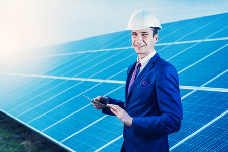 Solar panels. Engineer man with tablet on solar power station.
