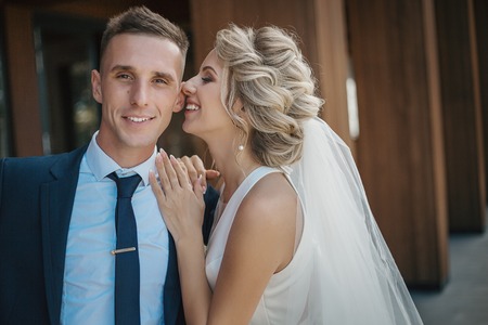 Wedding portrait of a young beautiful couple in love. Happy bride and groom on the background of a modern city.の写真素材