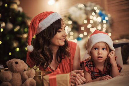 Happy family Mom with a daughter together on the background of Christmas decorations. Merry Christmas and Happy New Year!の写真素材