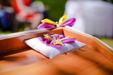 Wedding wedding rings on a white pillow with purple and yellow bowknot 1の写真素材