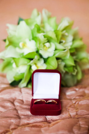 Wedding rings in red box on the green wedding bouquetの写真素材