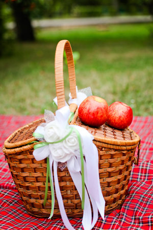 Basket with white ornaments and apples on a red blanket 1の写真素材