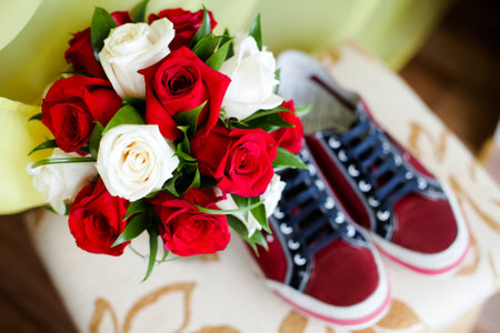 Red shoes on a brown floor with  bouquet of roses 1の写真素材