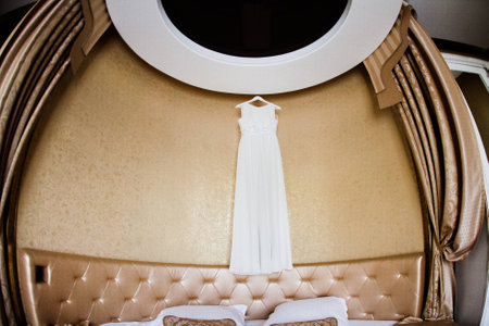 White wedding dress hangs in a beautiful interior 1の写真素材
