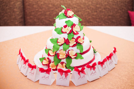 White wedding cake with red flowers on the table 1の写真素材