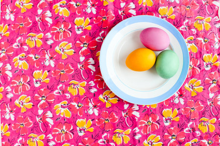 Easter egg on a colored table in the plateの写真素材