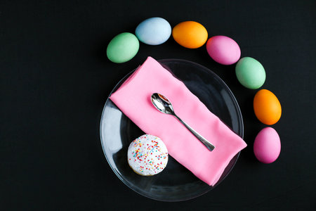The Easter cake and colourful Easter eggs on a black tableの写真素材