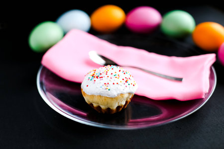 The Easter cake and colourful eggs on a black tableの写真素材