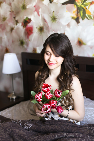 Girl with red flowers in the bed 1の写真素材