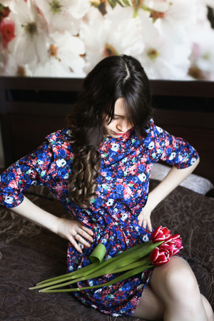 Girl with red flowers in the bedの写真素材