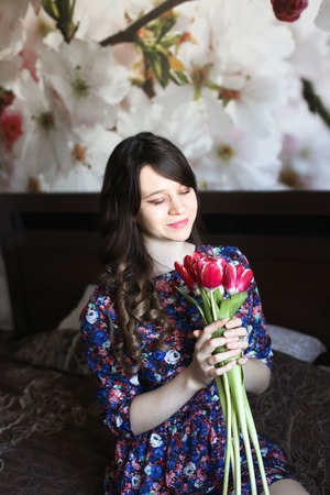 Girl with red flowers in the bedの写真素材