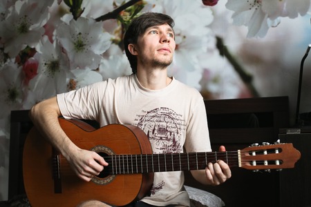 The guy on the bed playing classical guitarの写真素材