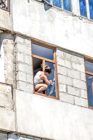 A woman washes a window in a high-rise buildingの写真素材