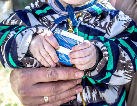 A small child holds a pack of cigarettesの写真素材