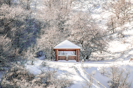 Wooden conversation covered with snow on the mountainside landscapeの写真素材