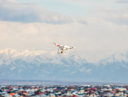 drone quad copter with high resolution digital camera flying hovering in the blue sky.