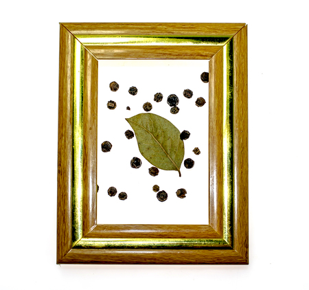 Dry bay leaf and black pepper on a white background