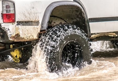 Car wheel in the dirt and waterの写真素材