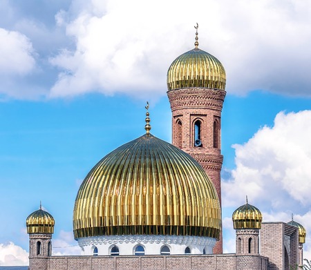 The Muslim mosque of the golden dome on the background of the sky with clouds