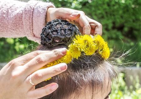 Wreath of dandelions on the head of a childの写真素材
