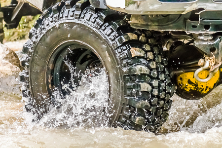 Car wheel in the dirt and waterの写真素材