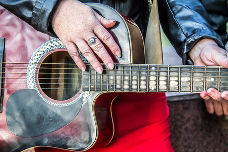 Guitar in the hands of an elderly woman