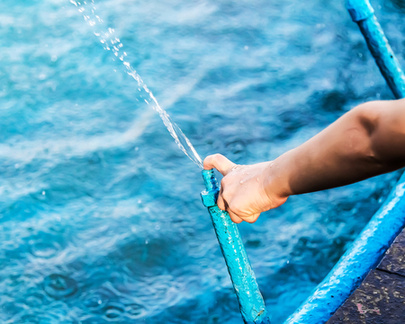 Hand of a child playing with a spray fountain