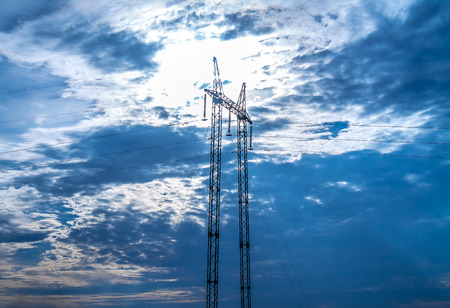 Metal high-voltage support against the backdrop of a stormy skyの写真素材