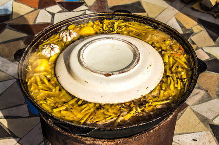 Cooking national Asian rice dish pilaf in metal pot outdoorの写真素材