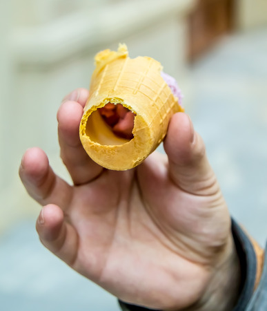 Blueberry ice cream in a waffle cup in handの写真素材
