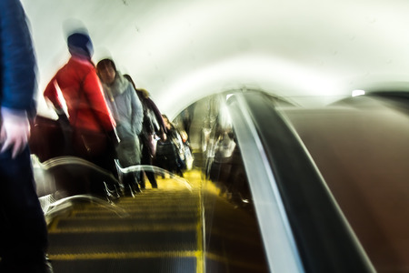 People on a moving escalator in the subway blur