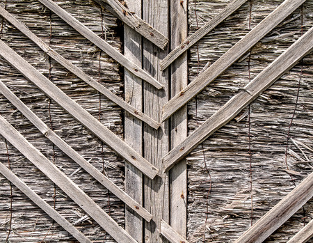 The texture of the old house of reeds and wooden shingles as a backgroundの写真素材