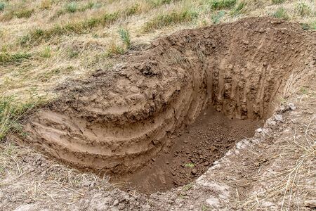 Deep hole in the ground dug by an excavator