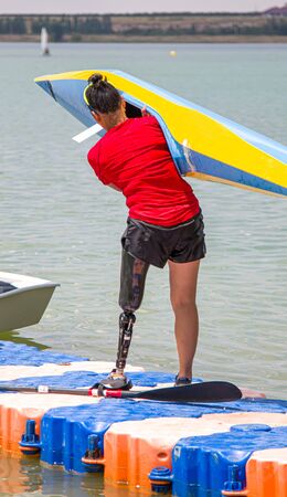A girl with a prosthetic leg is engaged in rowing. The concept of people with disabilities go in for sportsの写真素材