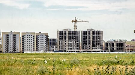 The construction of new high-rise buildings on a green field. The concept of the development of the cityの写真素材